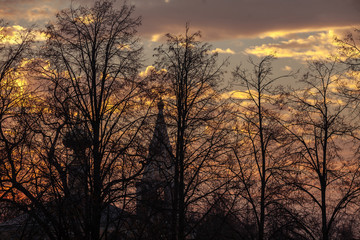 Silhouette of a church on a background of trees at sunrise.
