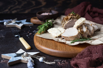 Obraz na płótnie Canvas Roast pork meat with onion, garlic and rosemary served with nuts butter on brown stone table. 