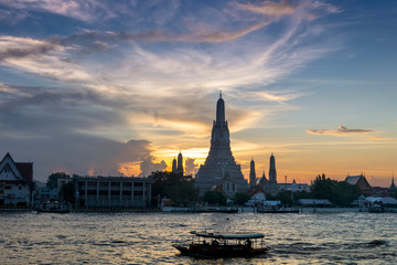 Fototapeta na wymiar Sunset silhouette of Wat Arun (Temple of Dawn) is the famous landmark landmark of Attractions's Popular tourists, in Chao Phraya river, bangkok Thailand