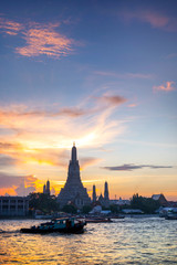 Fototapeta na wymiar Sunset silhouette of Wat Arun (Temple of Dawn) is the famous landmark landmark of Attractions's Popular tourists, in Chao Phraya river, bangkok Thailand