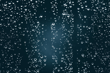 Dirty window glass with drops of rain. Atmospheric blue background with raindrops. Droplets and...