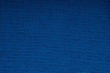 Fototapeta premium Blue knitted canvas texture closeup. Blur background