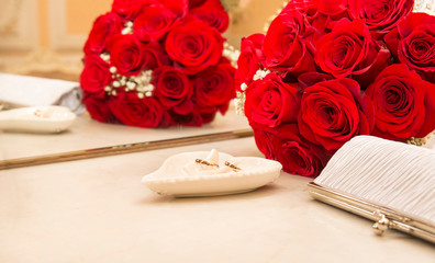 2 gold wedding rings, a bouquet of red roses