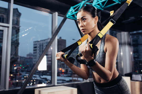 Athletic Asian Sportswoman Training With Resistance Bands In Fitness Center