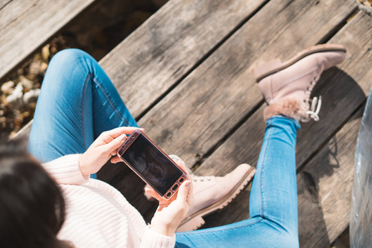 Top view of beautiful pregnant looking ultrasound image in her mobile phone.Concept of pregnancy, health care, gynecology, medicine. Young mother waiting of the baby.