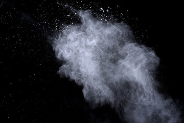 White powder explosion on black background. Dust splatted isolated. Paint Holi.
