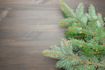 Spruce branches on a wooden table. Christmas composition, top view, space for copy.