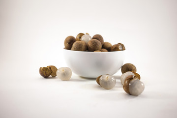 Fresh longan fruits in a white bowl isolated on white background