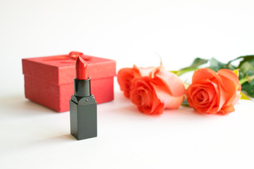 Beauty cosmetic white background with red lipstick, gift box and roses. Decorative composition with cosmetics and flowers. Makeup, Cosmetic products, Boxing day. Feminine Modern fashion mockup