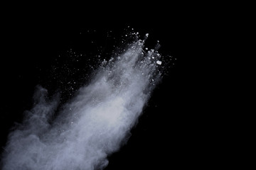 White powder explosion on black background. Dust splatted isolated. Paint Holi.
