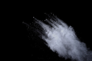 White powder explosion on black background. Dust splatted isolated. Paint Holi.