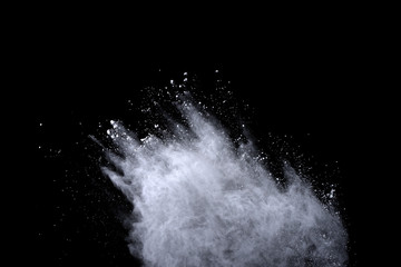 White powder explosion on black background. Dust splatted isolated. Paint Holi.