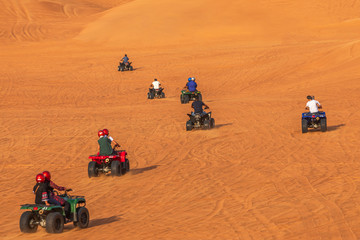 Tourists having fun riding Quad Bikes in dunes of Dubai Adventure Tour - 237769531