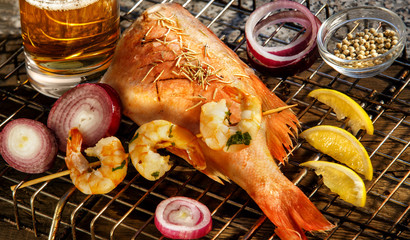 Fish dish cooking with various ingredients. Raw Sea bass with lemon, garlic, herbs and spices on cutting board, top view. Healthy food or diet nutrition concept.