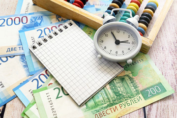 Russian money, alarm clock, notepad and bills. Business still-life