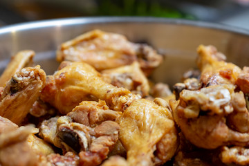 Naked chicken wings waiting for be tossed in sauce and then grilled.  In a large silver bowl close up in restaurant.