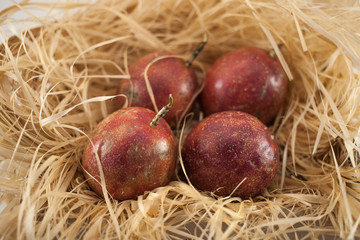 Four passion fruit isolated. Whole maracuyas on straw