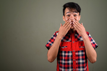 Young handsome Indian man against colored background