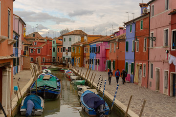 Fototapeta na wymiar Burano Island - part of Venice, colored houses on the background of the channel.