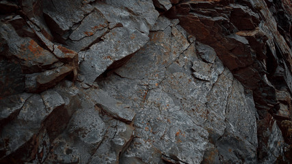 Stone texture close-up. The texture of the rock. Rock with streaks of rusty shades. Stone from the Ural mountains.