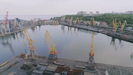 Aerial of Odessa businessport with square platform, cranes and barrels in summer