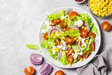 Tomato goat cheese corn salad with spicy dressing. Top view, space for text.