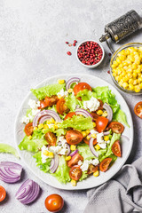 Tomato goat cheese corn salad with spicy dressing. Top view, space for text.