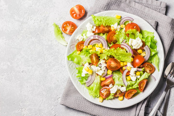 Tomato goat cheese corn salad with spicy dressing. Top view, space for text.