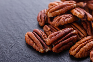 delicious pecan nuts on a dark stone background