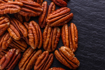 delicious pecan nuts on a dark stone background