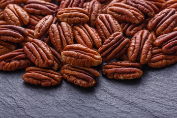 delicious pecan nuts on a dark stone background