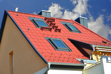 Mit rot beschichteten Metall-Ziegeln gedecktes Dach mit modernen Dachfenstern, Dachtreppe,...