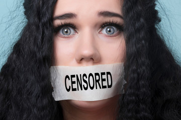 portrait of young woman with mouth and lips sealed in adhesive tape restrained and abused censored and banned to speak, concept of hostage - obrazy, fototapety, plakaty