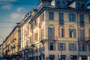 Fototapeta premium Old style buildings with balconies, windows and shutters in historical city centre of Turin Torino city, vintage photo, Piedmont, Italy