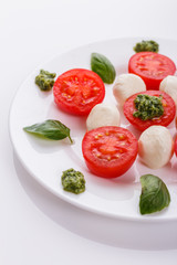 Caprese salad on a white acrylic background