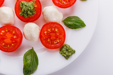 Caprese salad on a white acrylic background