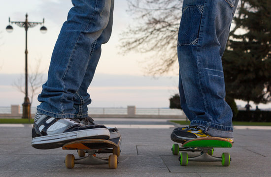 Two young guys stand on skateboards