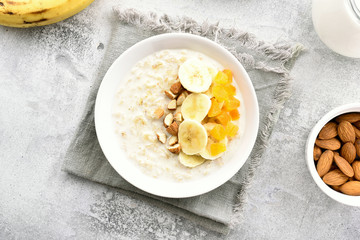 Oatmeal porridge with banana slices, almond and dried apricot