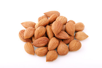 Dry apricot kernels on a white background.