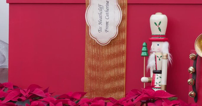 Small Red Nutcracker Standing Among Presents in Christmas / Holiday Display