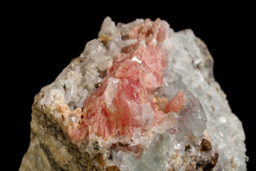 Macro of the mineral stone Rhodochrosite with fluorite on a black background