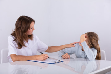 Obraz premium Doctor Sitting With Girl Patient In Clinic