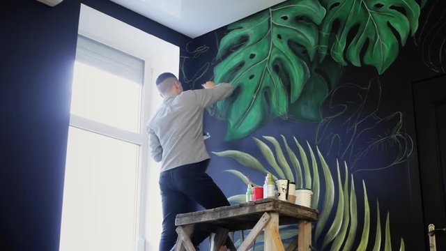 Drawing on the wall. Graffiti artist with brush. Art Concept.