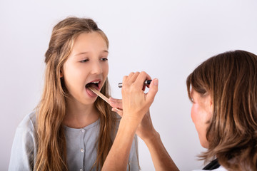 Doctor Checking Girl's Sore Throat