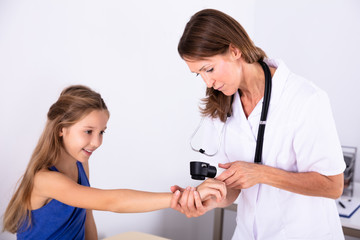 Female Doctor Examining Skin Of Girl