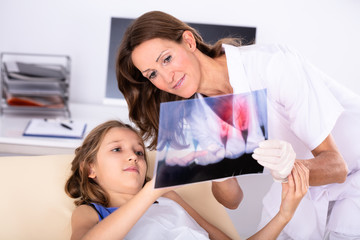 Dentist Showing Teeth X-ray To Girl