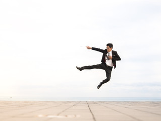 man wearing suit jumping outdoor