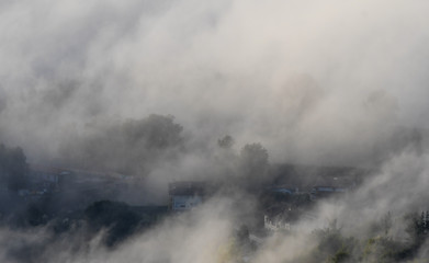 Fototapeta na wymiar Houses in the fog at sunrise from Mount Ubieta