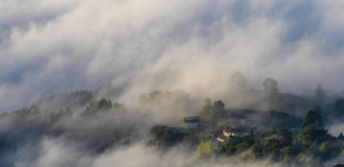 Houses in the fog at sunrise from Mount Ubieta