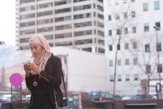 Woman using mobile phone in city 